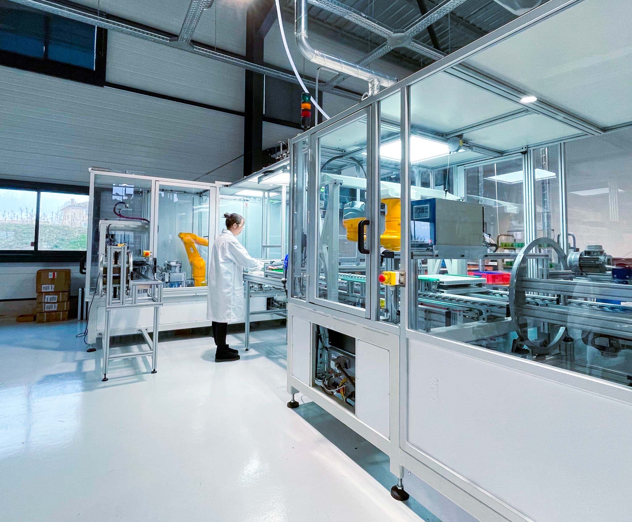 Technicienne travaillant sur une ligne automatisée dans l'usine Batteries Prod